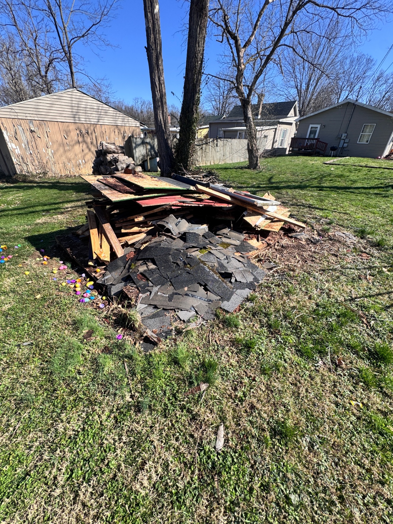 Pile of scrap wood and shingles in a backyard