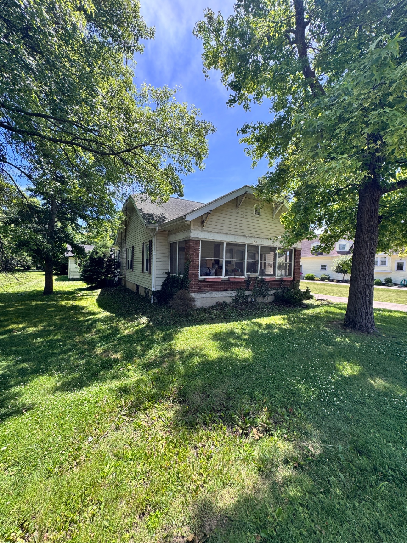 Bungalow front yard with shrubs cut back