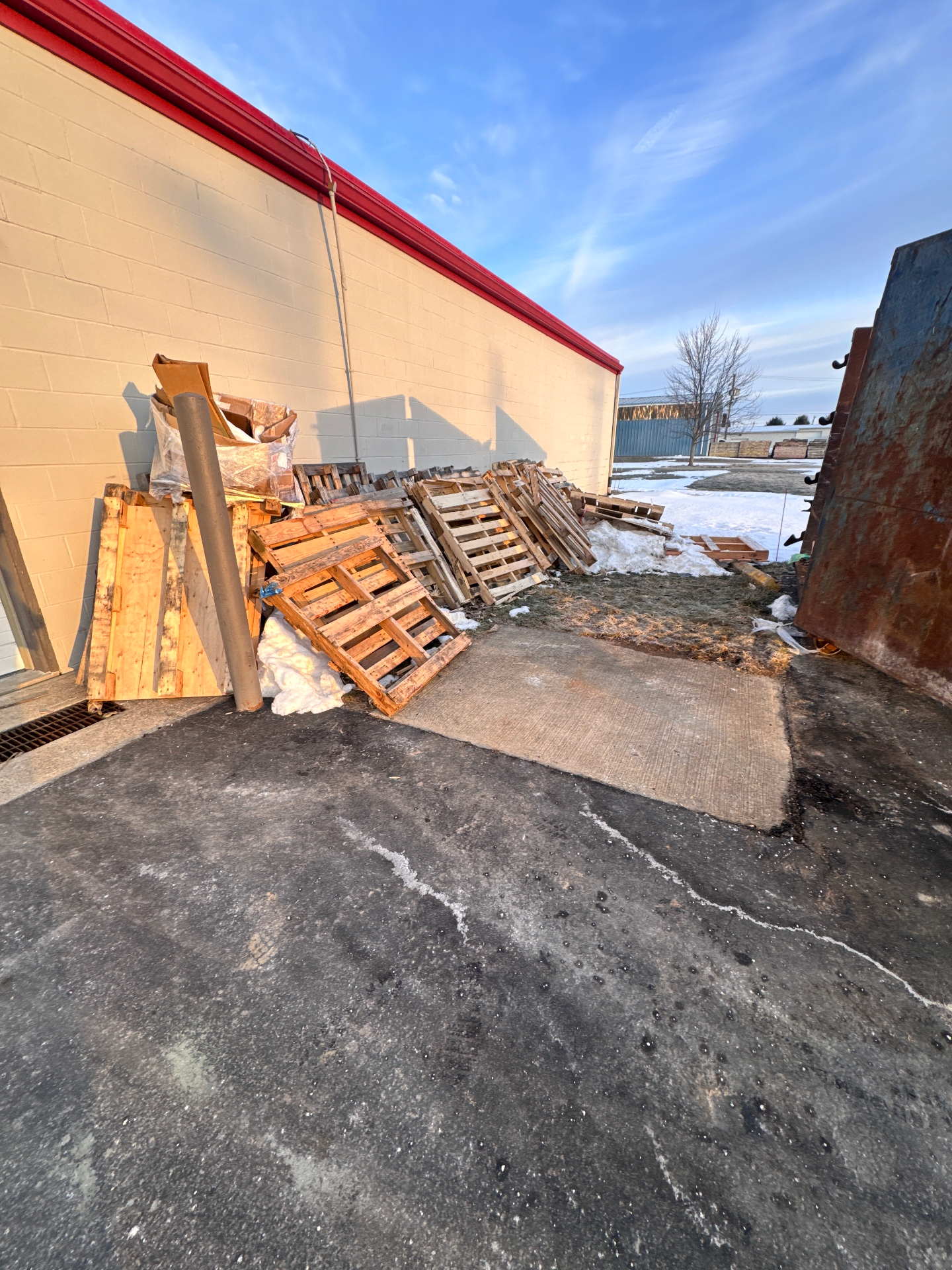 Pile of broken wooden pallets against a building